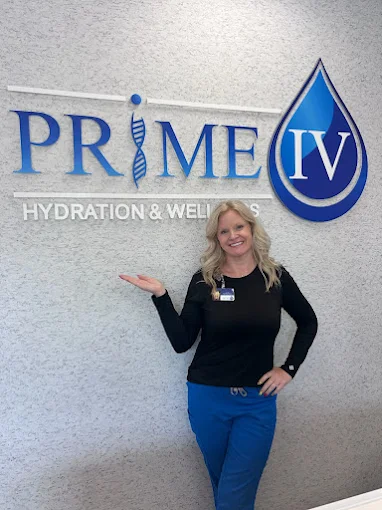 Prime IV team member by the Bluffton logo wall