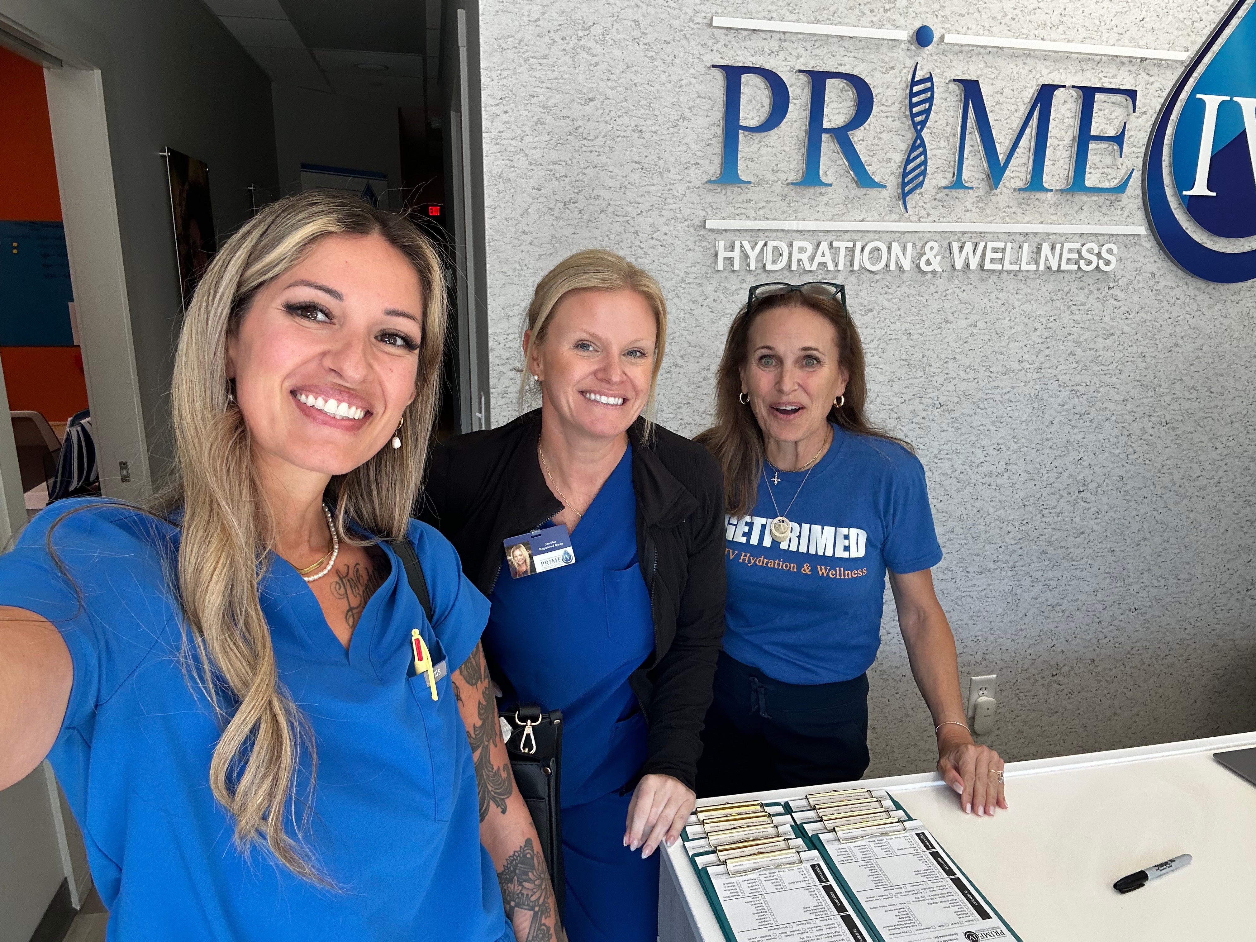 The friendly Prime IV Hydration & Wellness team smiling at the front desk, ready to welcome new guests